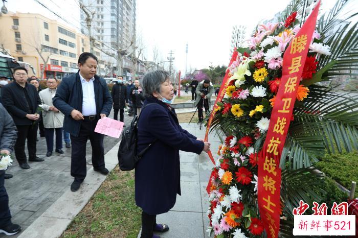 王铭章将军儿媳白光莲女士整理花篮缎带。　车文佳 摄