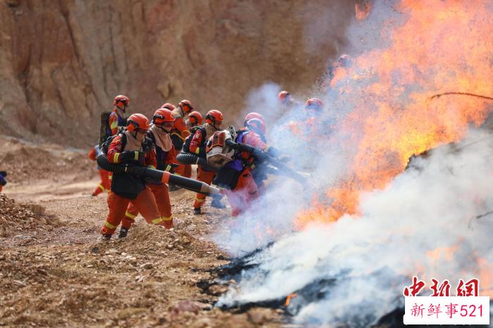 灭火行动中，消防员正在扑打火线。　李袁辉 摄