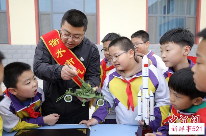 气象科普人员为学生展示气象设备模型。　陈康 摄