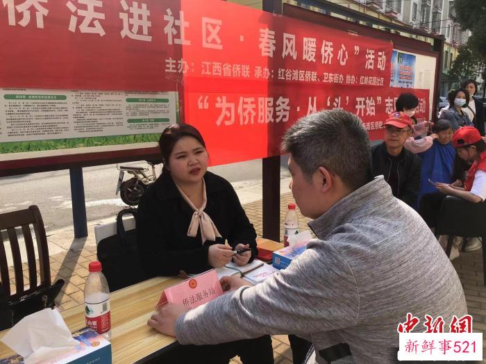 图为志愿服务者正在给侨胞科普侨法。　徐梦文 摄