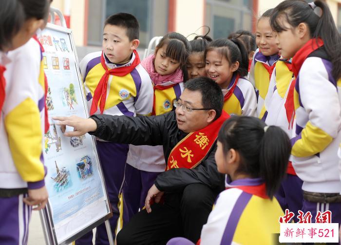 气象科普人员结合展板为学生普及气象知识。　陈康 摄