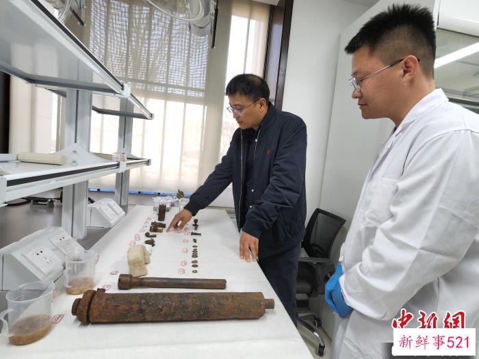 王泽冰(左)与兰栋交流出水文物修复情况。　赵晓 摄