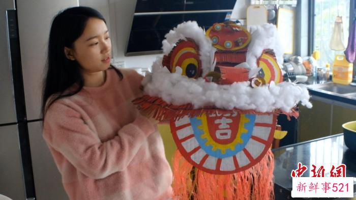图为田媚媚正在展示自己用旧纸壳制作的“狮头”。　刘俊聪 摄