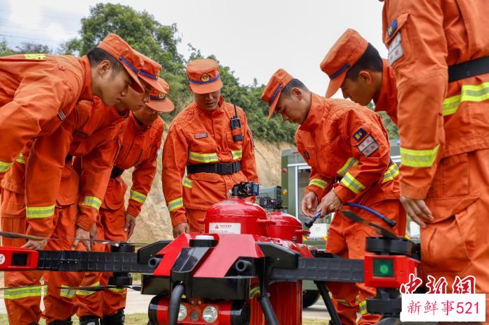 楼应佳与队员一同研究新型无人机。　福建省森林消防总队供图