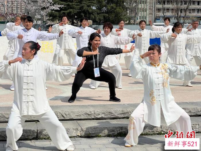 外籍友人与晨练的居民互动。　刘夏 摄