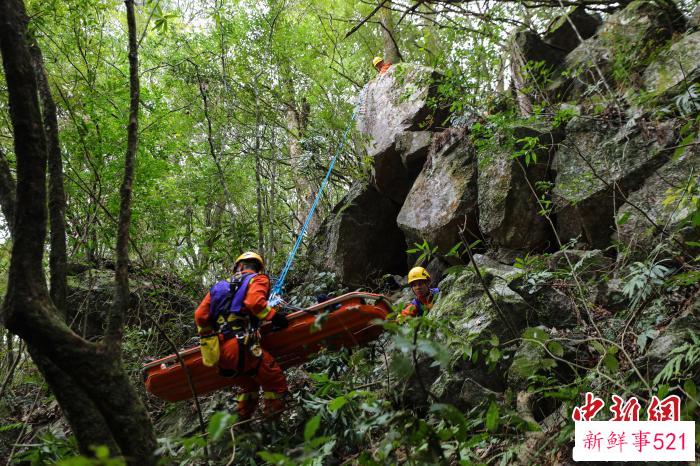 消防员利用绳索将伤员下降至崖底。　李袁辉 摄