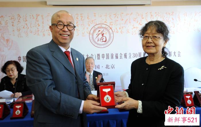 中国郭沫若研究会名誉会长、中国徐福会名誉会长郭平英(右)为中国徐福会执行会长兼秘书长李树杰颁发奖章。　王德成 摄