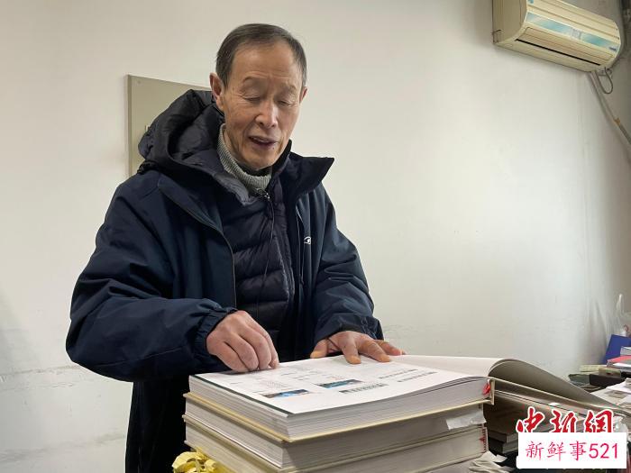 印开蒲翻看《百年变迁——两位东西方植物学家的影像重逢》。　祝欢 摄