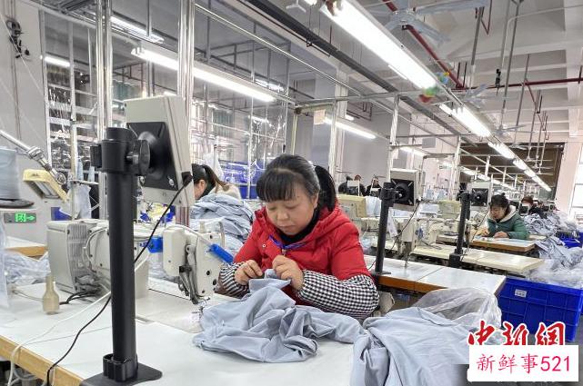 毕节市晶煌制衣有限公司生产车间工人赶制服装。　贵州省投资促进局供图