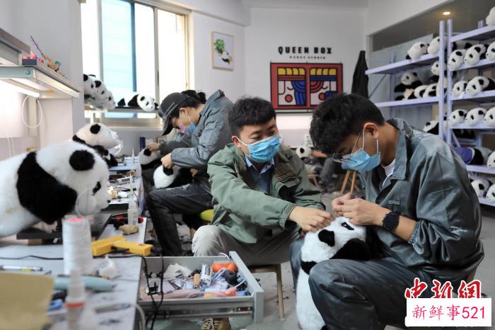 经过一番填充、剪毛和造型，一只只仿真大熊猫玩偶诞生。　王磊 摄