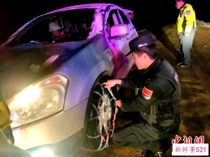 图为民警帮助游客安装车轮防滑链。　西藏林芝边境管理支队供图