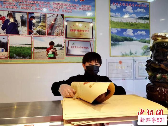 图为郑继梅正在打包烤鹅。　谢宏秀供图