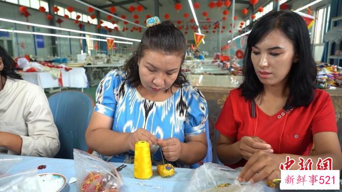 排丽旦·吐地和工人们一起制作手工串珠的“古丽娃娃”的帽子。　左丹丹 摄