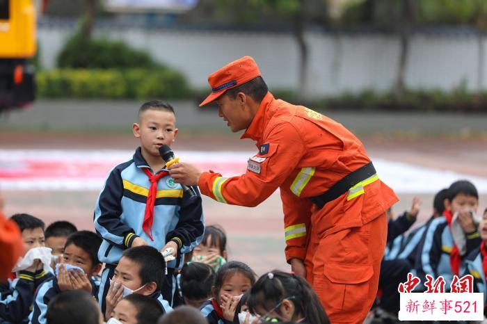 消防员正在和学生互动。　王治康 摄
