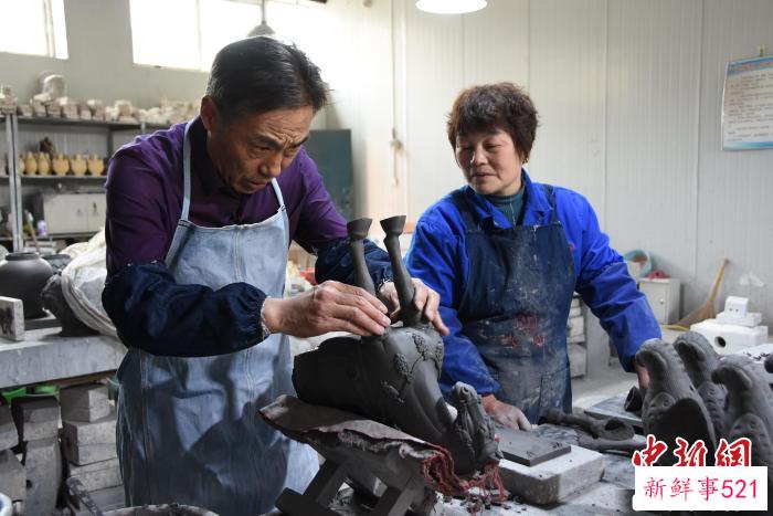 图为高水旺(左一)在指导徒弟制作唐三彩胎体。　　王宇 摄