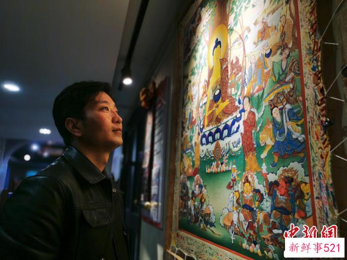 图为唐卡画师展示自己的作品。　张添福 摄