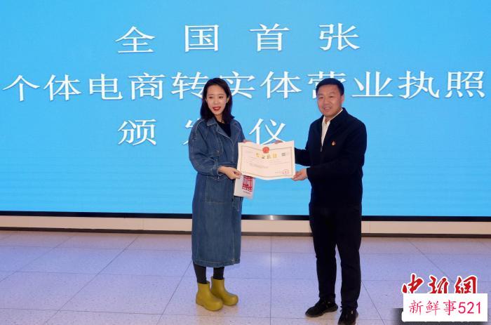 3月23日，个体工商户刘女士领取了变更后的营业执照，成为首家个体网店转变为实体个体工商户的经营者。　记者 张宇 摄