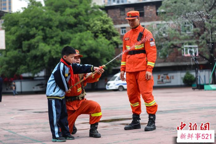 学生正在体验灭火装备。　王治康 摄