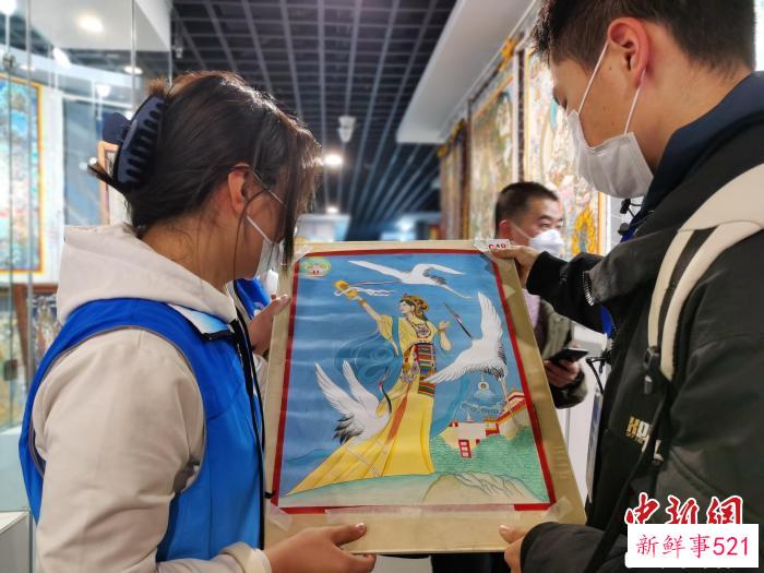图为唐卡画师展示自己的作品。　张添福 摄