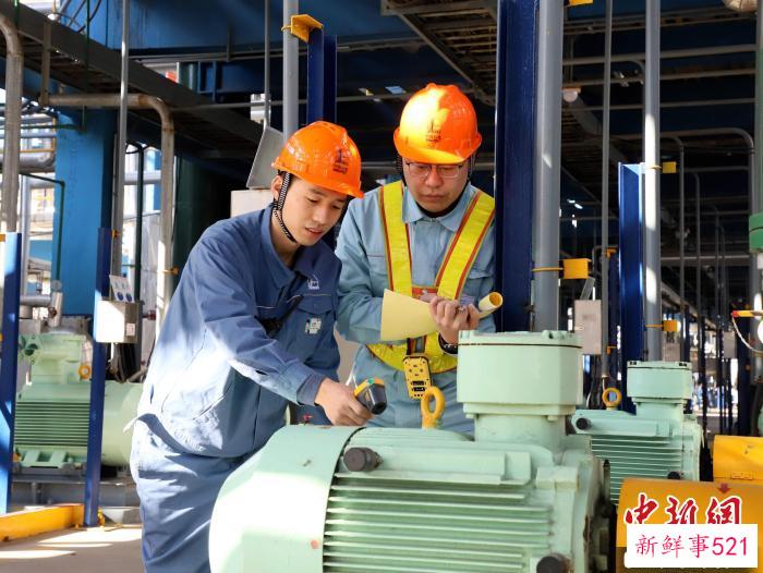 图为齐鲁石化员工巡检监测运转电机温度，确保设备安稳运行。　刘芳芳 摄