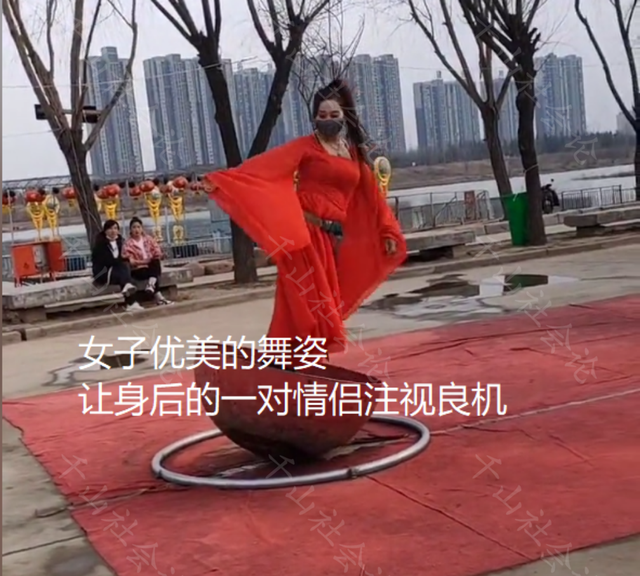 女子一袭红裙当街练舞，身后一位男子看的入迷，气的女友愤然离去