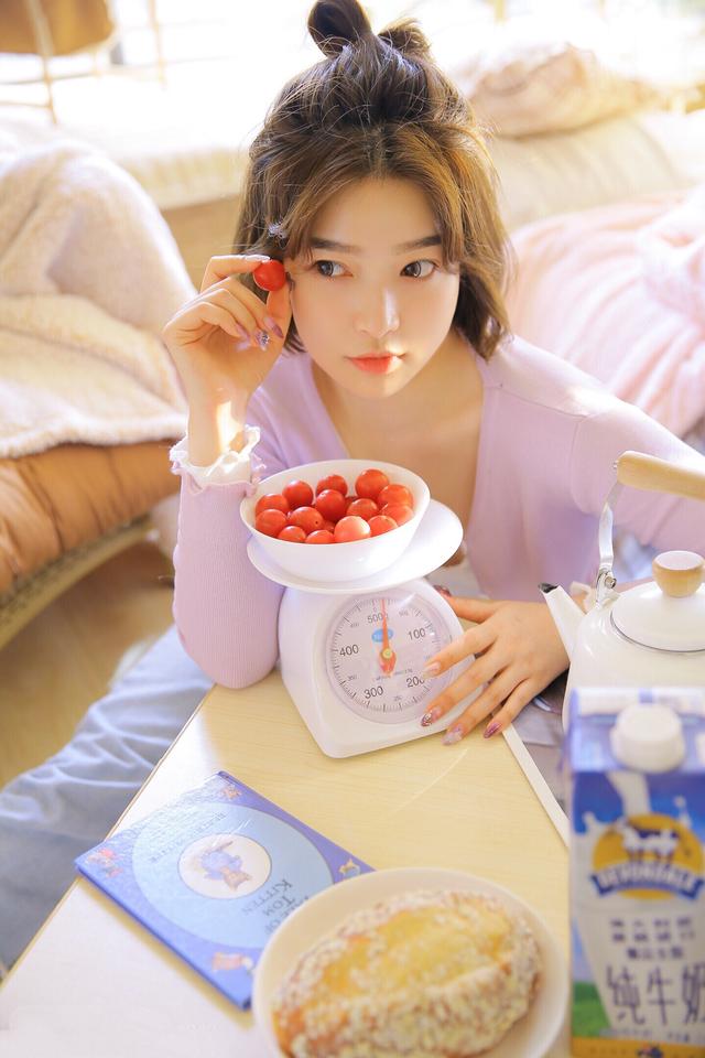 喜欢西红柿的美丽女孩，慵懒地依偎在沙发里格外可爱