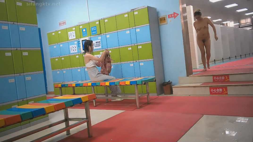 水上乐园更衣淋浴间出口附近移动偷拍救生圈后面几个妹子扎堆换衣服
