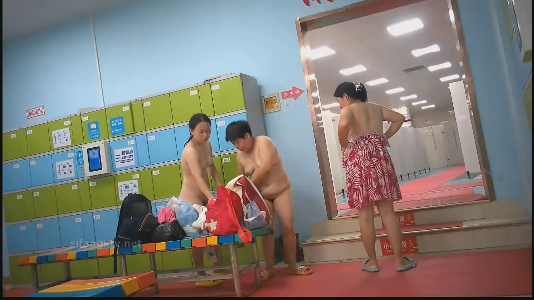水上乐园更衣淋浴间出口附近移动偷拍救生圈后面几个妹子扎堆换衣服