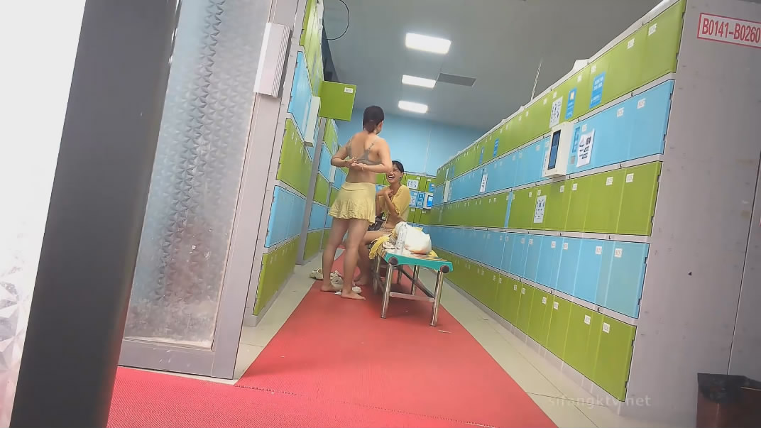 水上乐园更衣淋浴间出口附近移动偷拍救生圈后面几个妹子扎堆换衣服